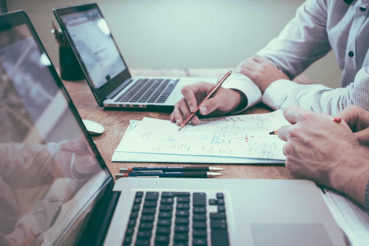 Profissionais analisando documentos e planejando ações comerciais